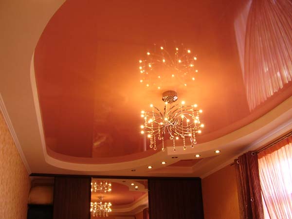фигурный потолок оранжевого полотна с двухярусной подсветкой
